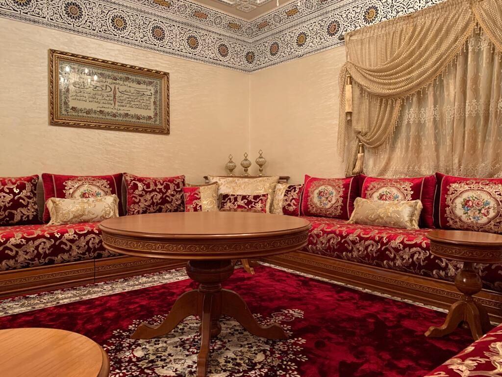 Salon marocain traditionnel avec banquettes et tapis